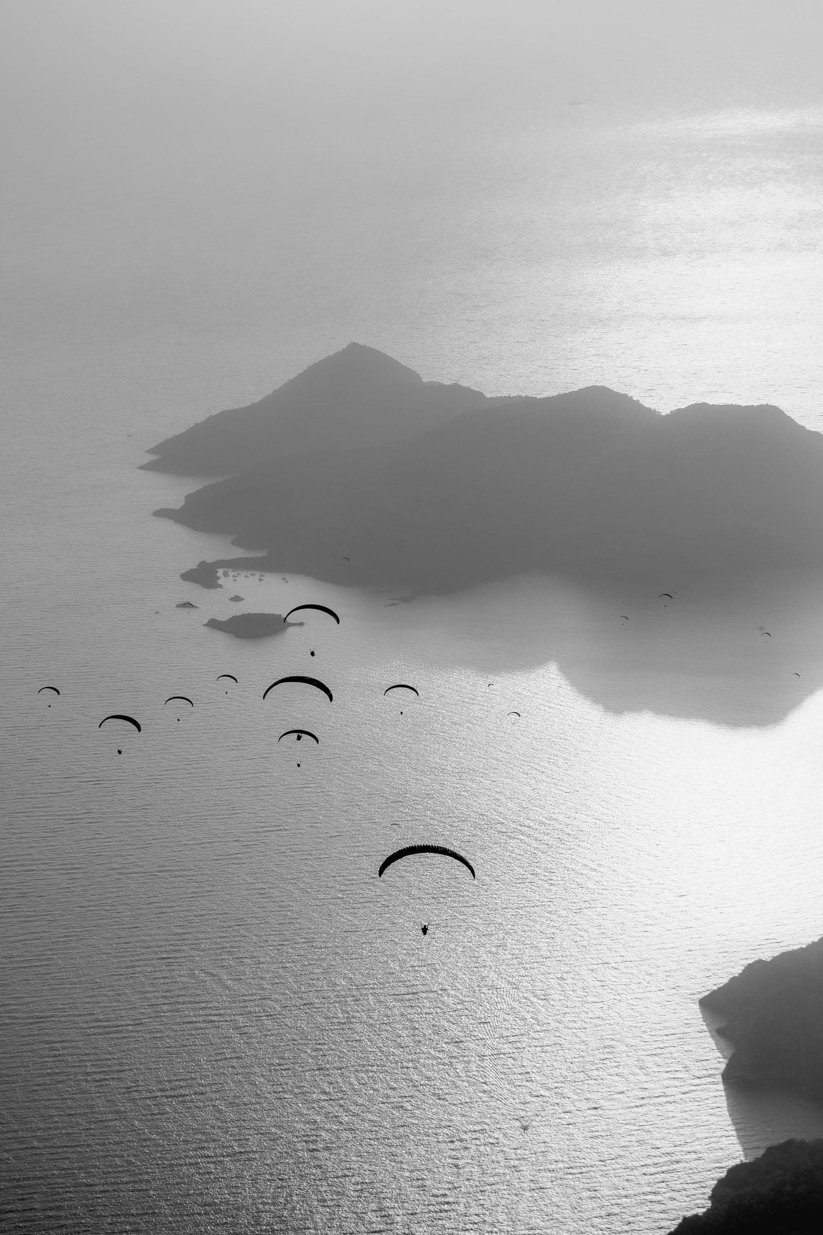 Dozens of paragliders above hazy islands